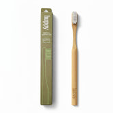 huppy bamboo toothbrush with eco-friendly olive green cardboard packaging showing soft bristles, plastic-free, and plant-based features alongside natural bamboo toothbrush with white bristles